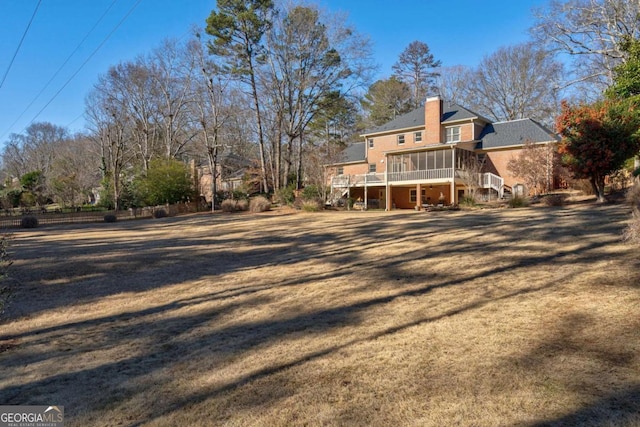 rear view of house with a sunroom and a wooden deck