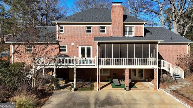 rear view of property with a sunroom, a patio area, and a wooden deck