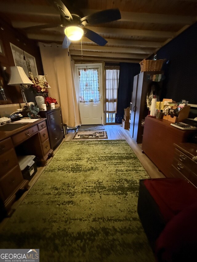 interior space with ceiling fan, beamed ceiling, and light hardwood / wood-style floors