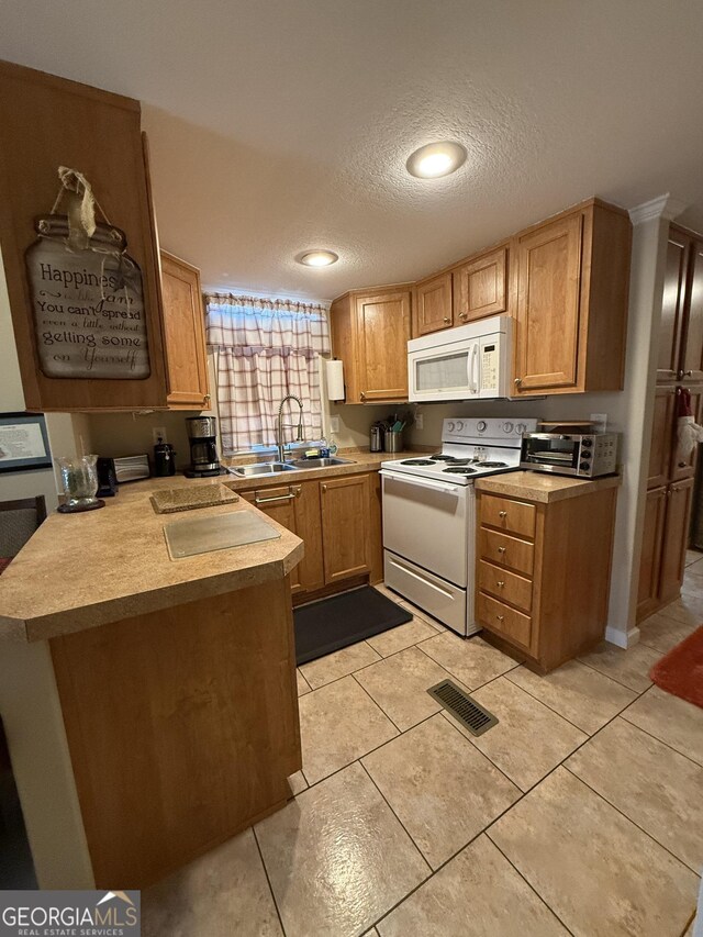 kitchen with kitchen peninsula, a textured ceiling, white appliances, sink, and light tile patterned floors