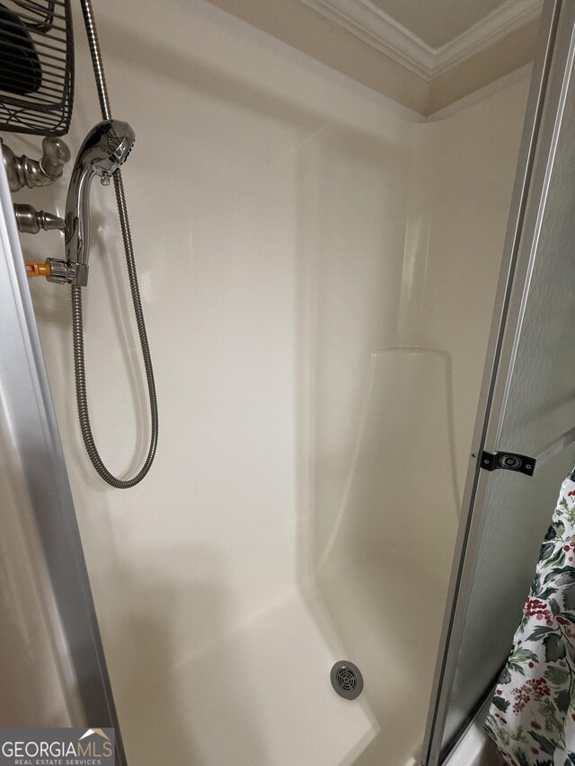 bathroom with walk in shower and ornamental molding