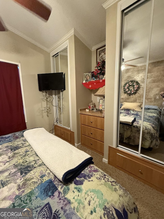 carpeted bedroom with a closet, ceiling fan, crown molding, and vaulted ceiling