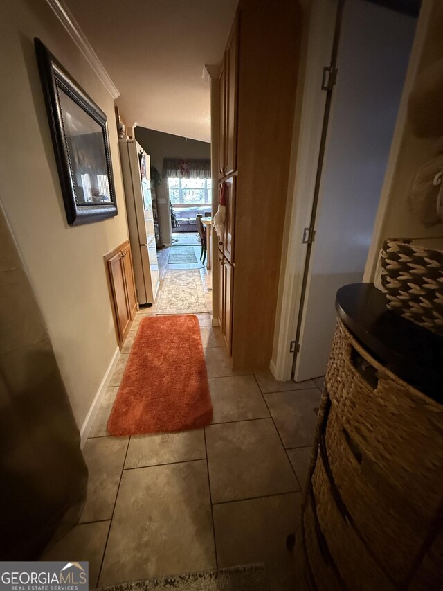 hallway with light tile patterned flooring and crown molding