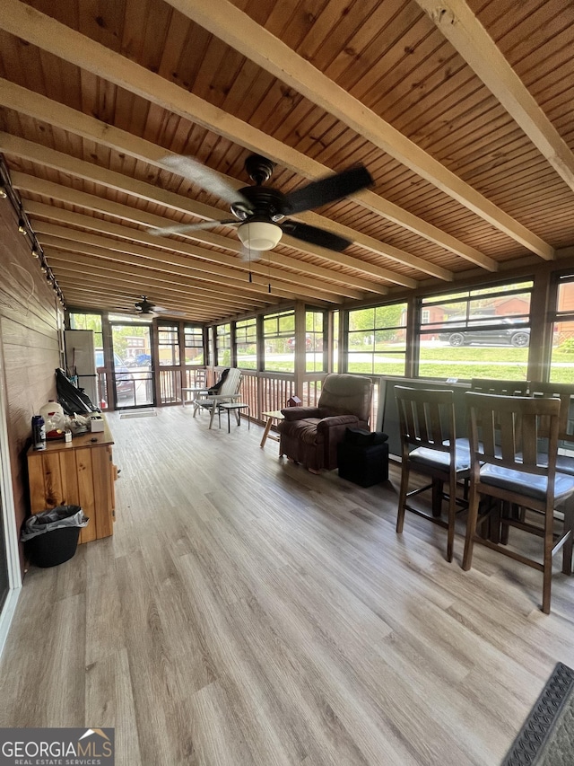 sunroom / solarium featuring ceiling fan, beamed ceiling, and wooden ceiling