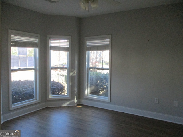 unfurnished room featuring ceiling fan, plenty of natural light, and dark wood-type flooring