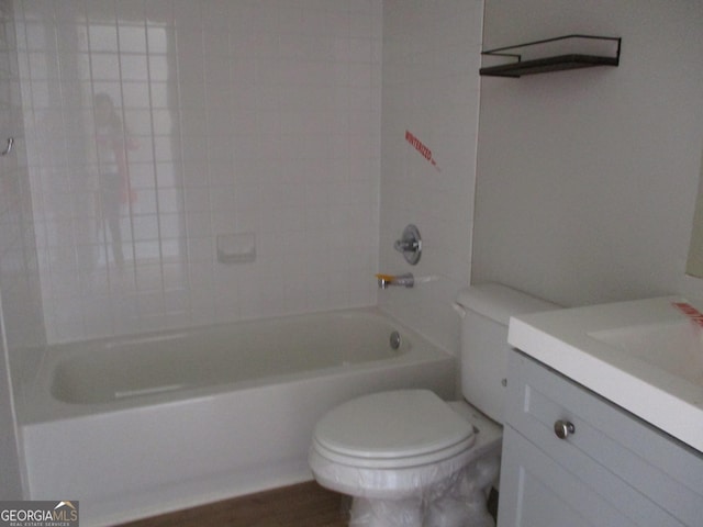 full bathroom with hardwood / wood-style floors, vanity, toilet, and tiled shower / bath combo