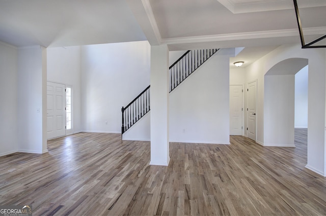 unfurnished living room with light hardwood / wood-style floors and crown molding