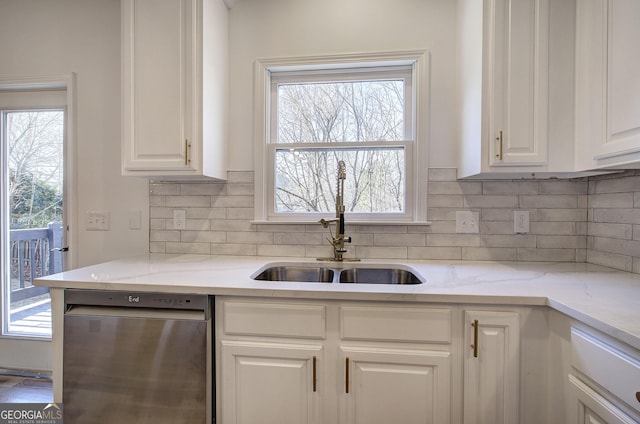 kitchen featuring sink, white cabinetry, stainless steel dishwasher, backsplash, and light stone countertops