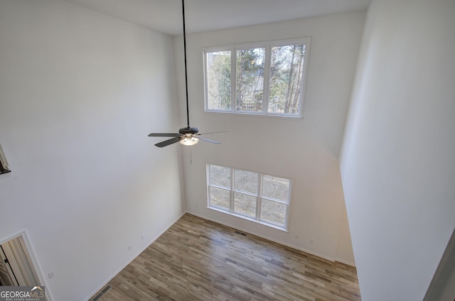 spare room with light wood-type flooring and ceiling fan