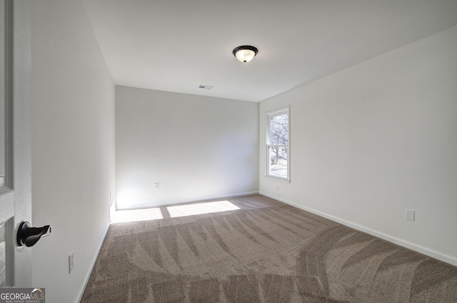 spare room featuring a fireplace and carpet floors