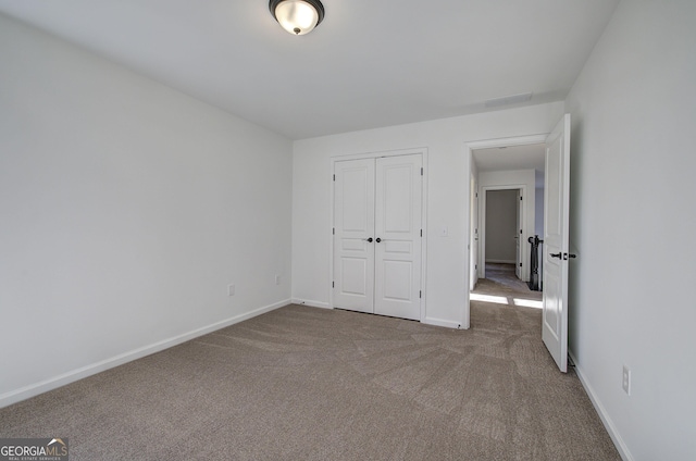 unfurnished bedroom with a closet and carpet flooring