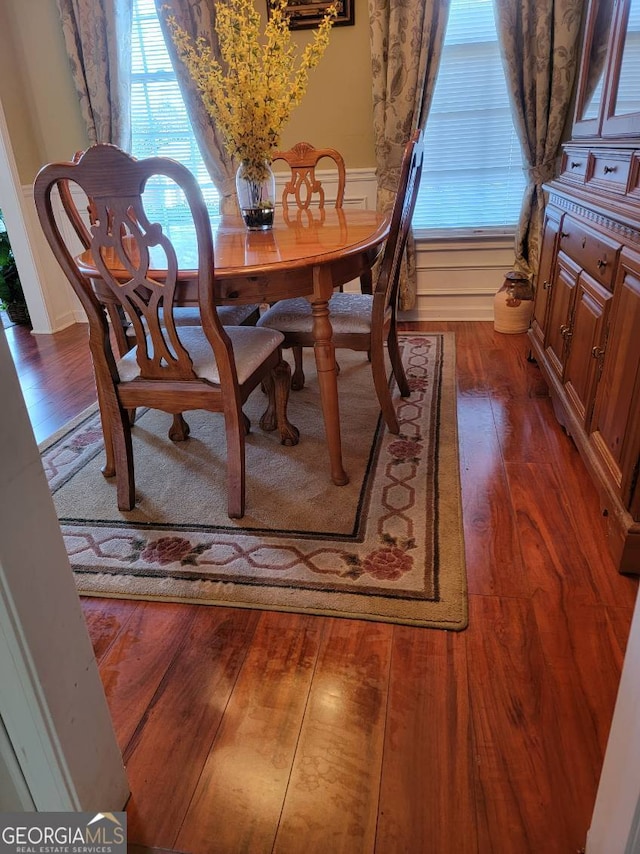 dining room featuring dark hardwood / wood-style flooring and a healthy amount of sunlight