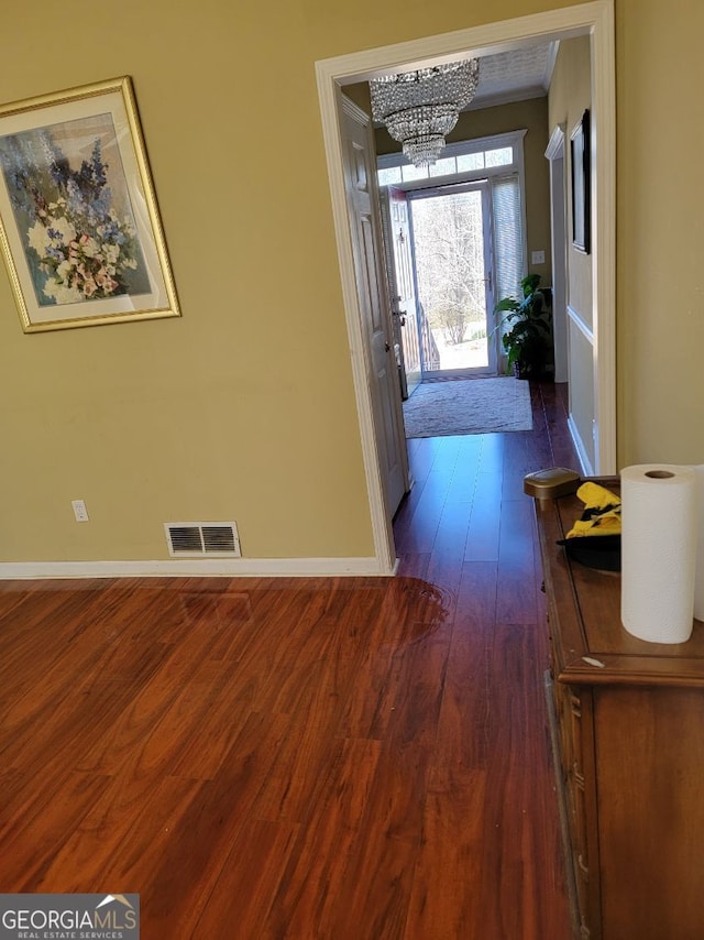 entrance foyer featuring dark wood-type flooring and a chandelier