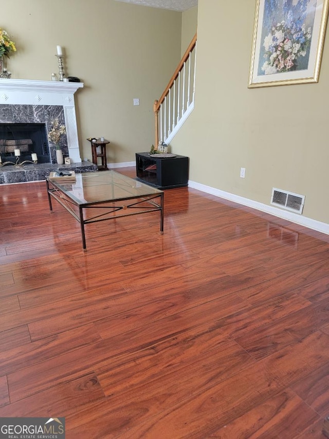 living room featuring wood-type flooring and a premium fireplace