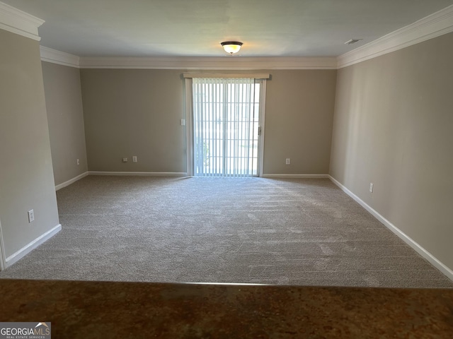 empty room featuring crown molding and carpet floors