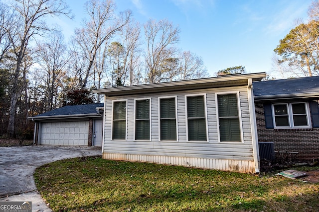 view of side of property with a garage and a lawn