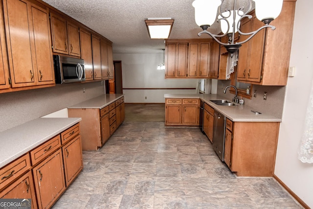 kitchen featuring decorative light fixtures, a notable chandelier, sink, stainless steel appliances, and a textured ceiling