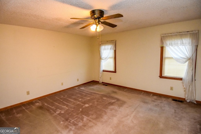 carpeted spare room featuring ceiling fan, plenty of natural light, and a textured ceiling