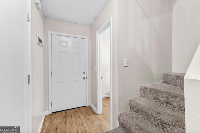 entrance foyer featuring a textured ceiling and light hardwood / wood-style flooring