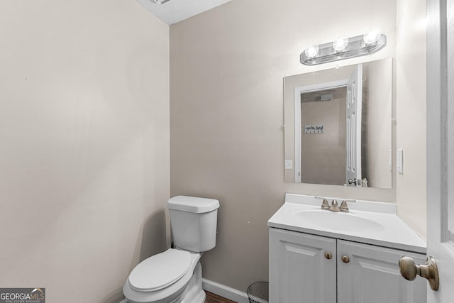 bathroom featuring vanity, a textured ceiling, and toilet