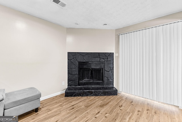 room details featuring a textured ceiling, wood-type flooring, and a fireplace