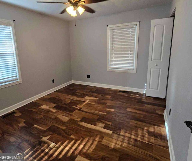 spare room featuring ceiling fan and dark hardwood / wood-style flooring