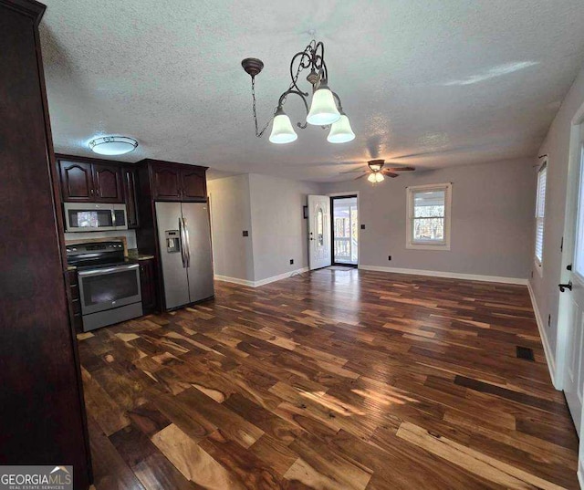 kitchen with dark brown cabinetry, stainless steel appliances, dark hardwood / wood-style flooring, decorative light fixtures, and a textured ceiling