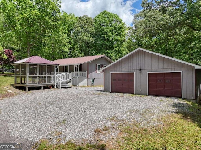 view of front of property with covered porch, a garage, and an outdoor structure