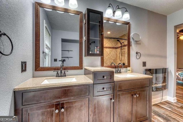 bathroom with vanity, a textured ceiling, hardwood / wood-style flooring, and walk in shower