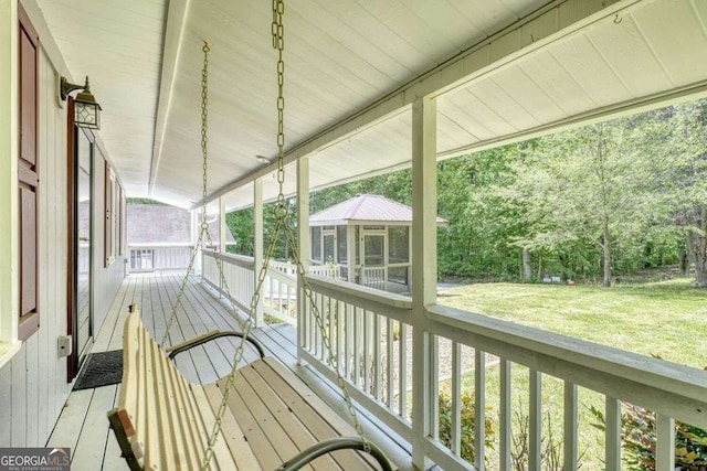 wooden deck with a sunroom and a yard