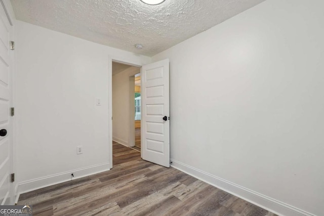 unfurnished room featuring hardwood / wood-style floors and a textured ceiling