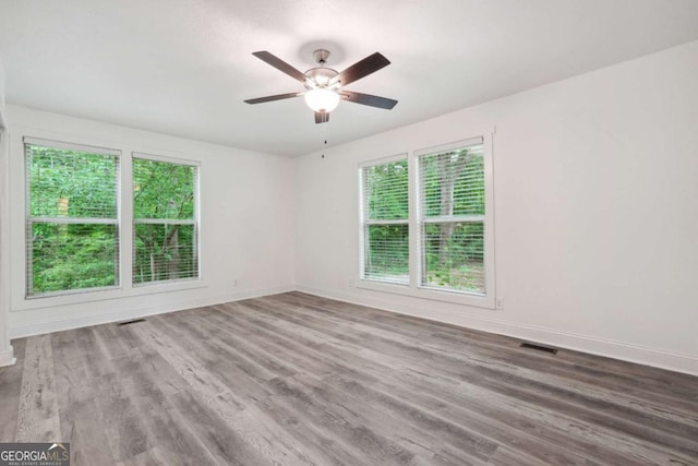 empty room with ceiling fan and hardwood / wood-style floors