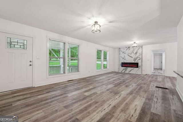 unfurnished living room featuring hardwood / wood-style floors and a high end fireplace