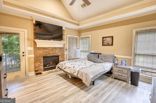 bedroom with access to exterior, light wood-type flooring, ceiling fan, crown molding, and a fireplace