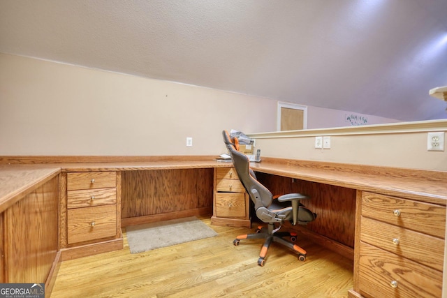 office area with light hardwood / wood-style flooring, built in desk, and lofted ceiling