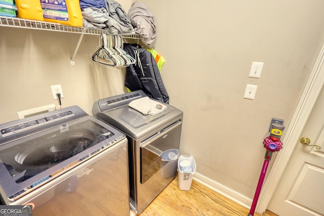 washroom featuring separate washer and dryer and light hardwood / wood-style flooring