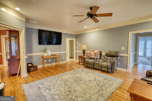 living room featuring ceiling fan, ornamental molding, and light hardwood / wood-style flooring