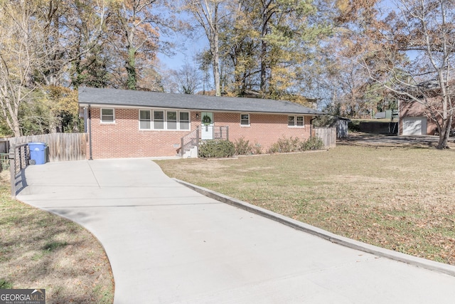 ranch-style home featuring a front yard, brick siding, fence, and driveway