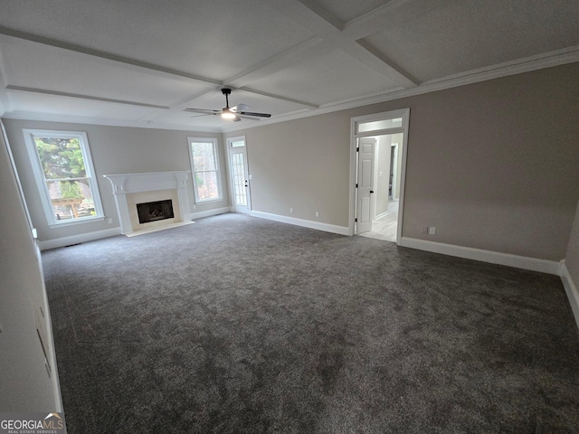 unfurnished living room featuring coffered ceiling, dark colored carpet, crown molding, ceiling fan, and beamed ceiling