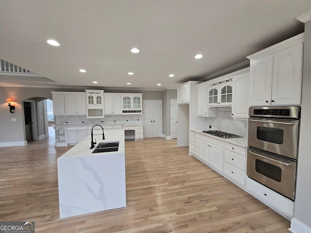 kitchen featuring stainless steel appliances, white cabinetry, tasteful backsplash, and sink