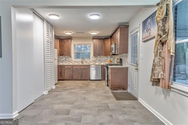 kitchen featuring appliances with stainless steel finishes, tasteful backsplash, and sink