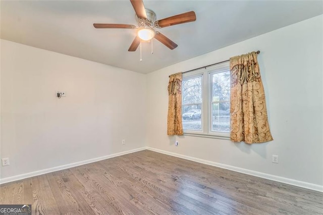 spare room with hardwood / wood-style flooring and ceiling fan