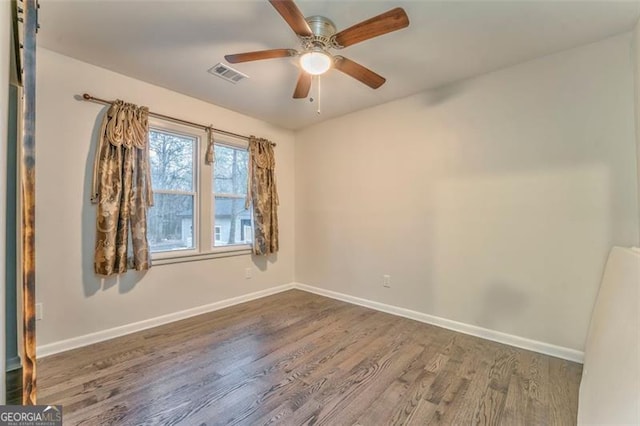 spare room featuring ceiling fan and dark hardwood / wood-style floors