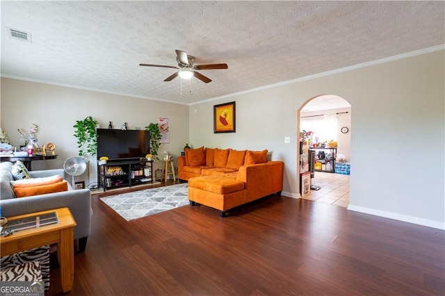 living room with a textured ceiling, crown molding, and hardwood / wood-style floors