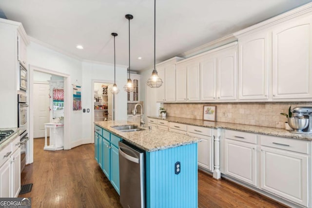 kitchen featuring sink, hanging light fixtures, blue cabinets, a center island with sink, and appliances with stainless steel finishes