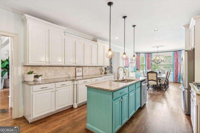 kitchen with appliances with stainless steel finishes, light stone counters, a kitchen island with sink, sink, and white cabinetry