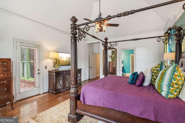 bedroom with wood-type flooring, access to outside, multiple windows, and lofted ceiling