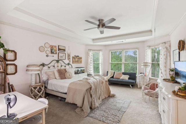 bedroom featuring a tray ceiling, multiple windows, and ceiling fan