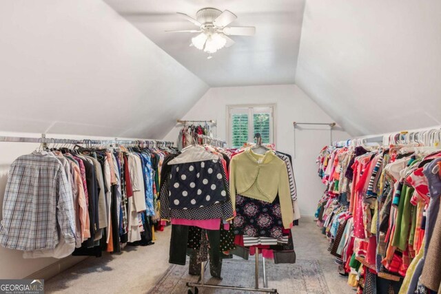 walk in closet with ceiling fan, light carpet, and vaulted ceiling