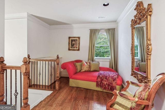 sitting room with wood-type flooring and ornamental molding